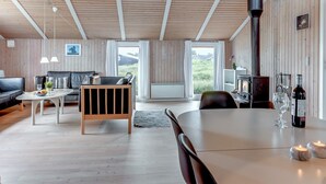 En hyggelig stue med en sofa, et spisebord med stearinlys og en pejs.