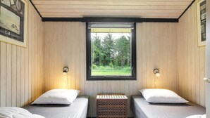 A room with two single beds, a window with a view of greenery, and wall-mounted light fixtures. - "Biergh" - 600m from the sea by Interhome (Løkken)