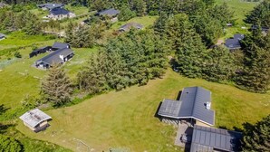 An aerial view of a residential area with multiple houses surrounded by dense forests and a coastal backdrop. - "Biergh" - 600m from the sea by Interhome (Løkken)