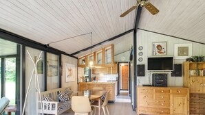 A modern kitchen with wooden cabinets, a dining area with a table and chairs, and a ceiling fan. - "Biergh" - 600m from the sea by Interhome (Løkken)