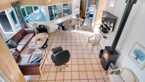 Ein modernes Interieur mit Kamin, Essbereich und Wohnbereich mit Blick auf einen Pool.