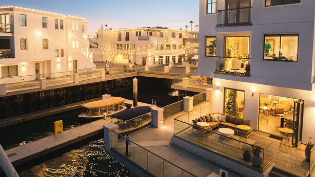 A modern building with a rooftop terrace, a pool, and a view of the water. - The Boardroom Residence at Peninsula Village (Newport Beach)