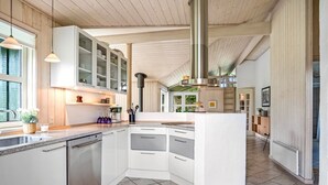 A modern kitchen with white cabinetry, a central island, and a large window.