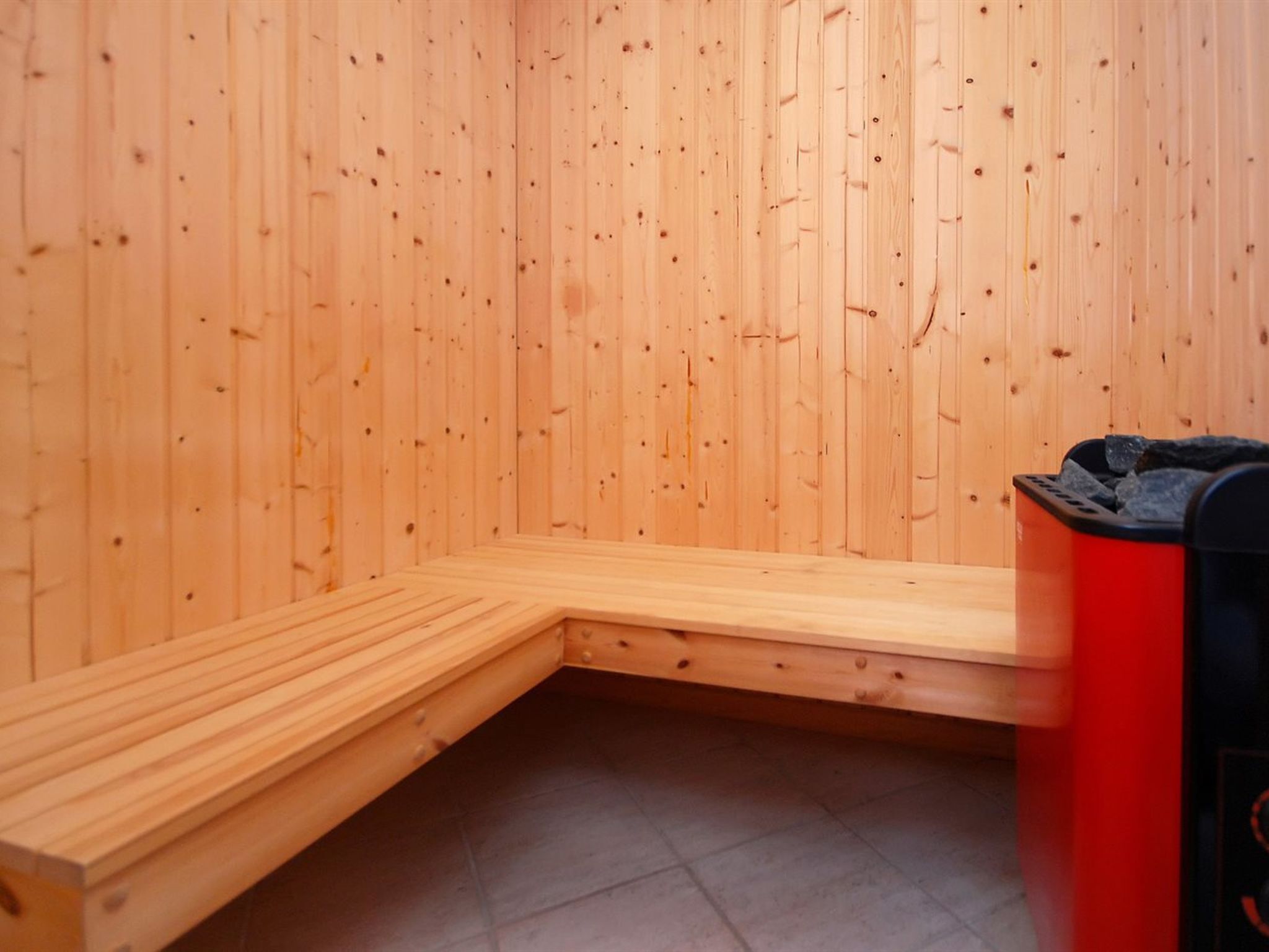 Een sauna met houten wanden en een bank.