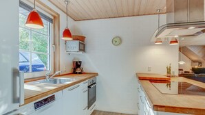 A modern kitchen with wooden cabinets, a built-in oven, a microwave, and a coffee maker. - "Friederk" - 12km from the sea by Interhome (Oksbøl)