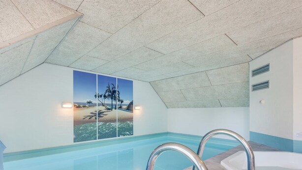 An indoor swimming pool with clear water, a hot tub, and a wall with a tropical beach mural. - "Friederk" - 12km from the sea by Interhome (Oksbøl)