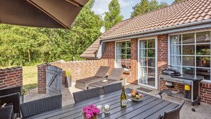 A patio with a dining table, chairs, a grill, and a brick wall. - "Friederk" - 12km from the sea by Interhome (Oksbøl)
