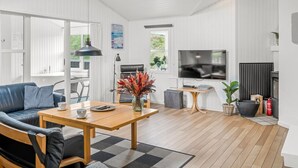 Ein modernes Wohnzimmer mit Sofa, Couchtisch, Fernseher und Kamin.
