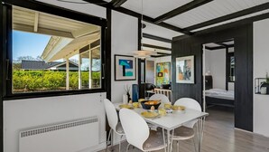 A modern dining area with a white table and chairs, a view of the outdoors, and artwork on the walls. - "Sigbrith" - 350m to the fjord by Interhome (Tarm)