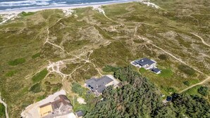 An aerial view of a coastal property with two main buildings, a sandy beach, and a forested area. - "Ewy" - 300m from the sea by Interhome (Ringkøbing)