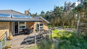A modern house with a patio, solar panels, and a forested area. - "Ewy" - 300m from the sea by Interhome (Ringkøbing)