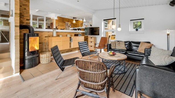 A spacious living area with a fireplace, a dining table, and comfortable seating. - "Ewy" - 300m from the sea by Interhome (Ringkøbing)