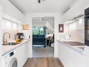 A modern kitchen with a built-in washing machine, a dining area with a view, and a cozy seating space. - "Lilo" - 1km from the sea by Interhome (Blåvand)