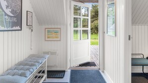 A room with a bed, a bench, a door leading outside, and a framed map on the wall.
