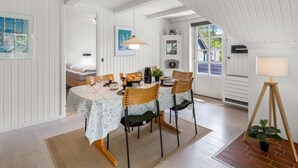 A dining area with a round table, chairs, and a lamp.