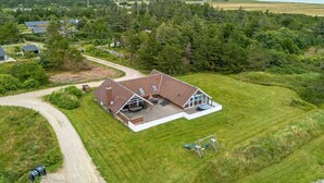 An aerial view of a house with a large lawn, a patio, and a swing set. - "Tuomi" - 900m from the sea by Interhome (Ringkøbing)