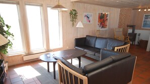 A cozy living room with a sofa, coffee table, and a fireplace. - "Riborg" -  from the sea by Interhome (Ringkøbing)