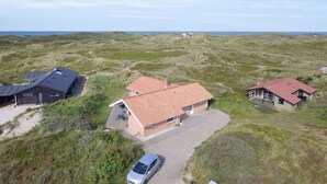 A coastal property with three houses, a gravel driveway, and a car parked in front. - "Riborg" -  from the sea by Interhome (Ringkøbing)