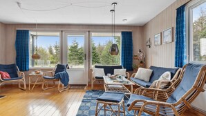 A spacious living area with wicker furniture, a blue sofa, and a dining table. - "Andria" - 300m from the sea by Interhome (Hals)