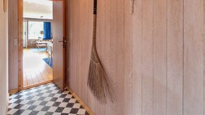 A hallway with a checkered floor, wooden walls, and a broom hanging on the wall. - "Andria" - 300m from the sea by Interhome (Hals)