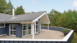 A modern house with a covered patio, large windows, and a chimney. - "Guththorm" - 600m from the sea by Interhome (Blåvand)