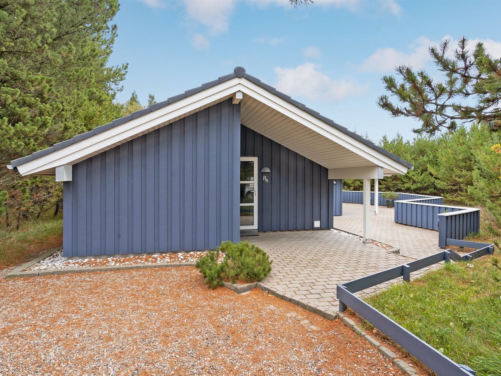 Un bâtiment moderne doté d’un toit en pente et d’un porche abrité.