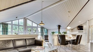 A modern living room with a leather sofa, a glass coffee table, and a dining area with chairs and a table. - "Guththorm" - 600m from the sea by Interhome (Blåvand)