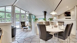 A modern dining area with a round table, black chairs, and a white ceiling. - "Guththorm" - 600m from the sea by Interhome (Blåvand)
