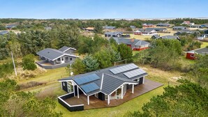 Een woonwijk met moderne huizen, zonnepanelen en een verzorgd gazon.