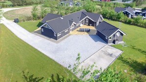Une grande maison dotée d’un vaste patio, d’un garage et d’une allée.