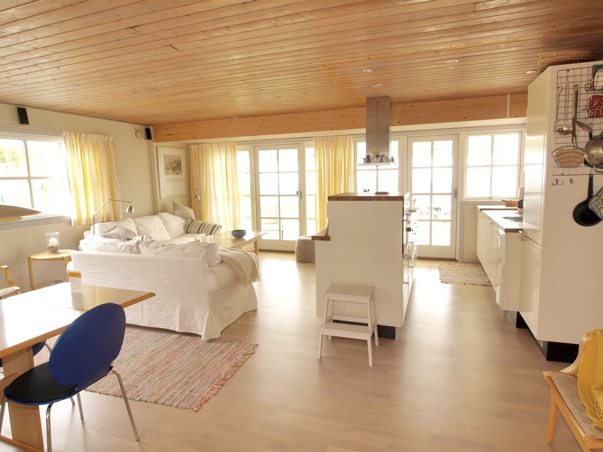 A spacious room with a bed, a desk, a chair, and a kitchenette.