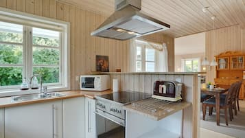 Een koelkast, een magnetron, een vaatwasser, kookgerei, borden en bestek