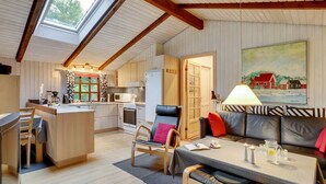 Un intérieur de chalet chaleureux comprenant une cuisine, un coin repas et un salon.