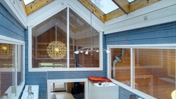 A modern interior with a skylight, large windows, and a chandelier.