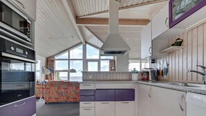 A modern kitchen with a built-in oven, a large window, and a view of the sea. - "Keti" - 5m from the sea by Interhome (Nyborg)