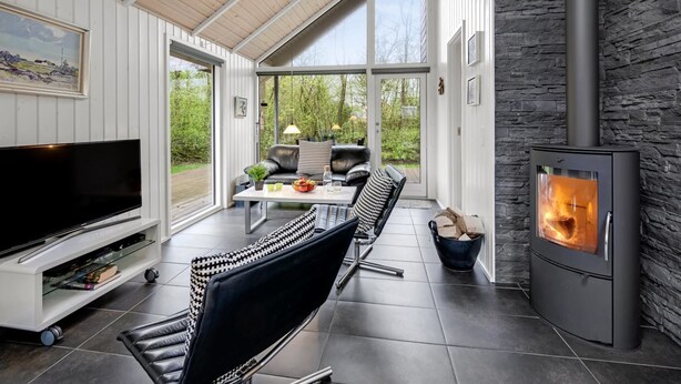A modern living room with a stone fireplace, a flat-screen TV, and a comfortable seating area with a view of the outdoors. - "Ketilbiorn" - 1.2km to the fjord by Interhome (Hemmet)