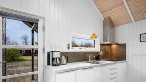 A modern kitchen with white cabinets, a stainless steel sink, and a coffee maker. - "Ketilbiorn" - 1.2km to the fjord by Interhome (Hemmet)