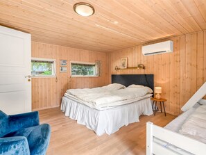 Une chambre à coucher comprenant un lit, une chaise, une fenêtre et un appareil de climatisation.
