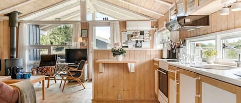 A spacious kitchen with wooden cabinets, a central island, and a dining area with a TV.
