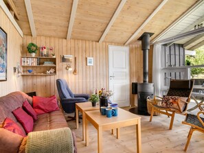 A cozy room with a wooden interior, a sofa, a chair, a table, and a fireplace. - "Anthonia" - 1.6km from the sea by Interhome (Blokhus)
