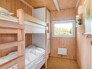 A wooden cabin with bunk beds, a window with a view, and a radiator. - "Anthonia" - 1.6km from the sea by Interhome (Blokhus)