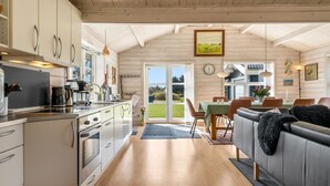 A spacious kitchen with modern appliances and a dining area with a view of the outdoors.