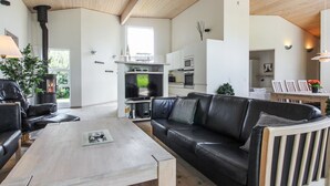 Een moderne woonkamer met een bank, een salontafel en een open haard.