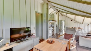 A modern interior with a TV, wooden table, and seating area.