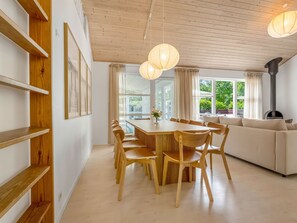 Ein modernes Interieur mit einem Holztisch, Stühlen, einer Couch und einem Kamin.