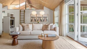 A modern living room with a sofa, coffee table, and artwork on the wall. - "Börje" - 600m from the sea by Interhome (Væggerløse)