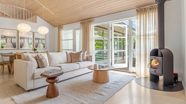 A modern living room with a sofa, coffee table, and a wood-burning stove.