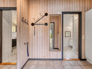 A modern interior with a wooden wall, a mirror, and a coat rack. - "Martina" - 560m to the fjord by Interhome (Hemmet)