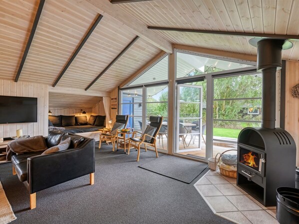 A modern interior with a fireplace, a sofa, and a dining area.
