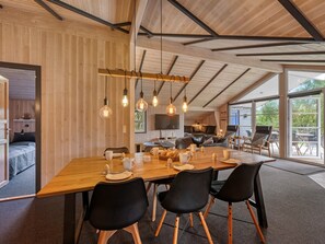 A modern interior with a wooden dining table, black chairs, and hanging light fixtures. - "Martina" - 560m to the fjord by Interhome (Hemmet)